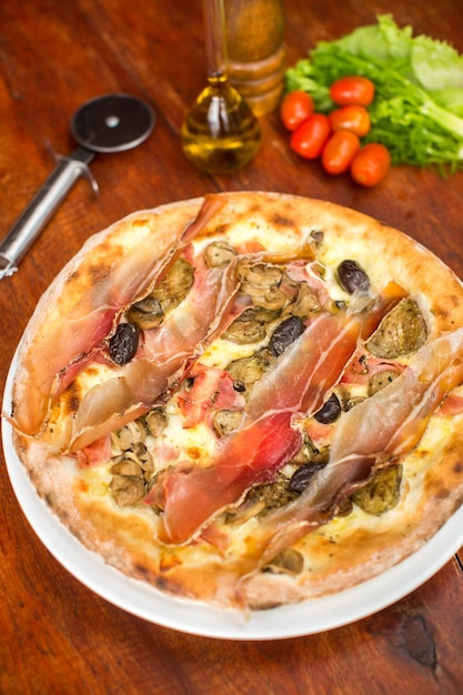 Photo gratuite pizza à la viande assortie avec jamon et olives