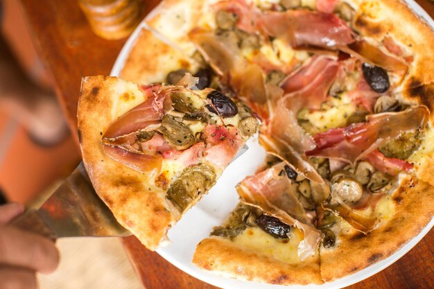 Pizza à la viande assortie avec jamon et olives