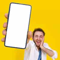 Photo gratuite placement de produit pour la publicité d'applications mobiles offre exceptionnelle jeune homme heureux tenant un smartphone montrant un écran blanc vide