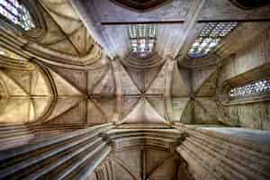 Photo gratuite le plafond à l'intérieur d'une cathédrale historique avec des arcs et des vitraux