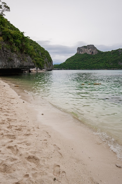 Plage sur l'île tropicale. Eau bleue claire, sable, nuages.