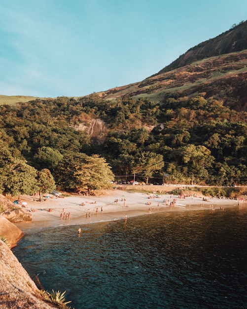 Plage peuplée avec beaucoup de gens profitant d'une belle journée d'été