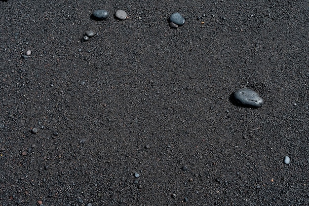 Plage de sable noir avec galets. Rive sablonneuse volcanique de Tenerife.