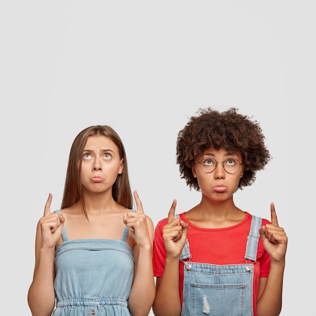 Photo gratuite plan candide d'étudiants abattus avec des expressions sombres, lèvres inférieures de sac à main