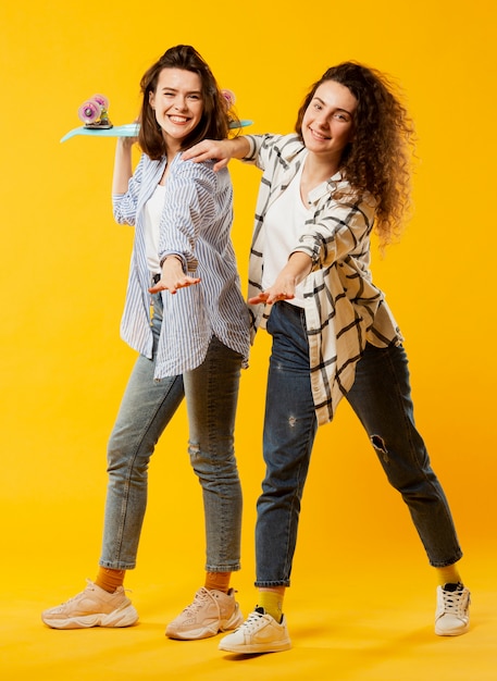 Plan complet de belles femmes avec planche à roulettes