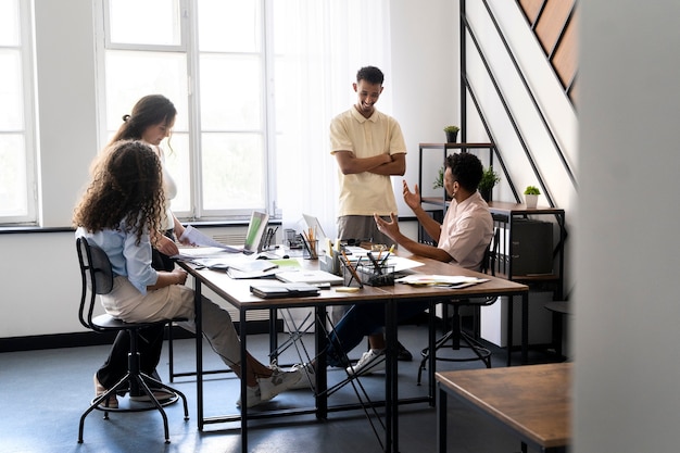 Plan complet de différentes personnes travaillant ensemble