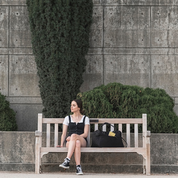 Plan complet femme assise sur un banc