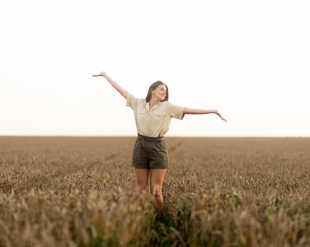 Plan complet d'une femme dans un champ de fleurs