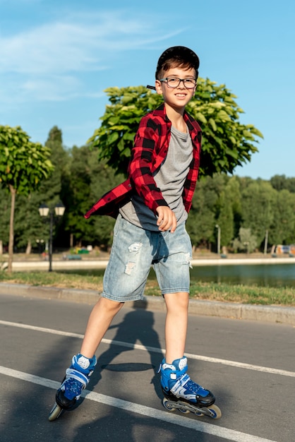 Photo gratuite plan complet d'un garçon avec des patins à roues alignées