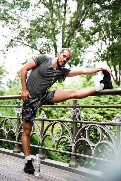 Photo gratuite plan complet d'un homme qui s'étend dans un parc