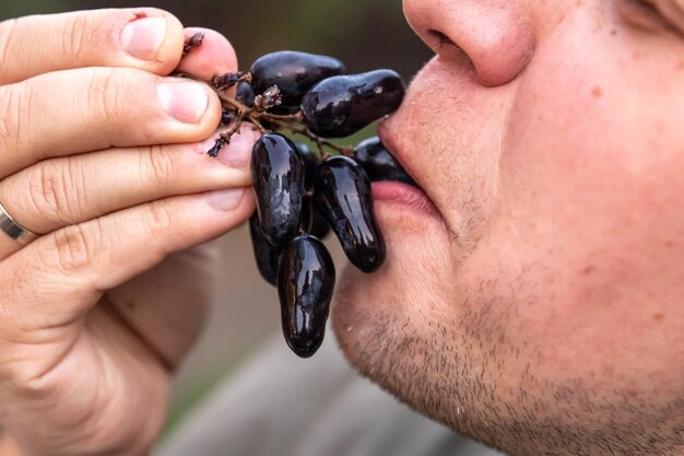 Photo gratuite plan détaillé d'un homme mangeant du raisin