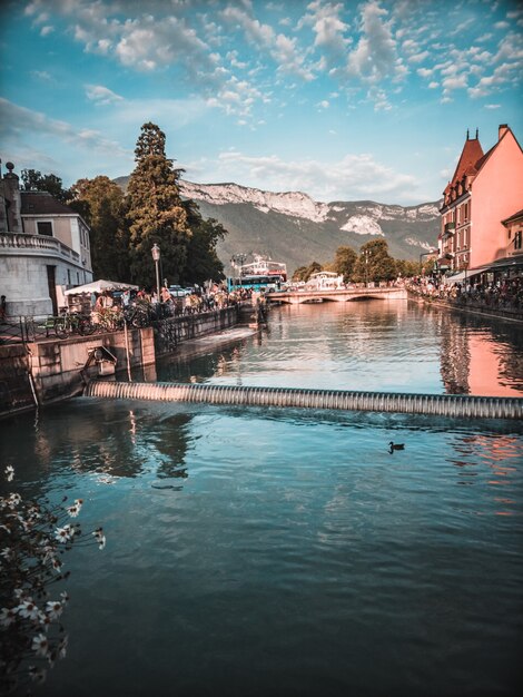 Plan d'eau entre maisons et montagnes au loin