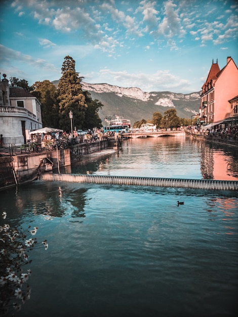 Plan d'eau entre maisons et montagnes au loin