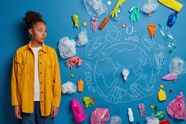 Plan d'une femme bénévole sérieuse concentrée de côté, activiste de l'écologie, réfléchit à la façon de sauver la planète de la pollution plastique, a beaucoup de pensées, ramasse les déchets pour le recyclage.