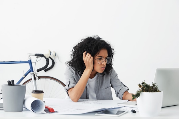 Plan d'une femme à la peau foncée entrepreneur fatigué portant de grandes lunettes