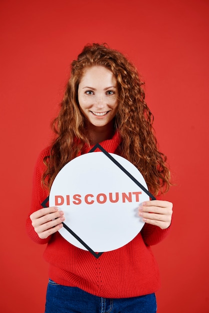 Plan d'une femme souriante montrant une bannière de soldes d'hiver