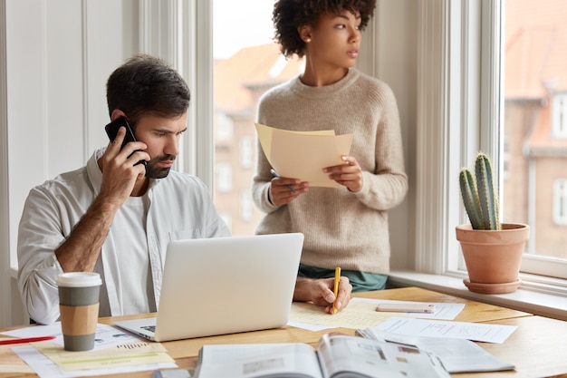 Plan d'un homme sérieux note des informations au cours d'une conversation téléphonique