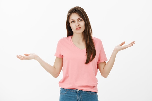 Plan intérieur d'une femme brune mécontente qui pose en studio