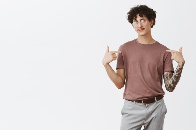 Plan intérieur d'un homme juif artistique et créatif confiant, aux cheveux bouclés et à la moustache, debout dans une pose sûre de lui, se montrant fièrement comme un candidat parfait