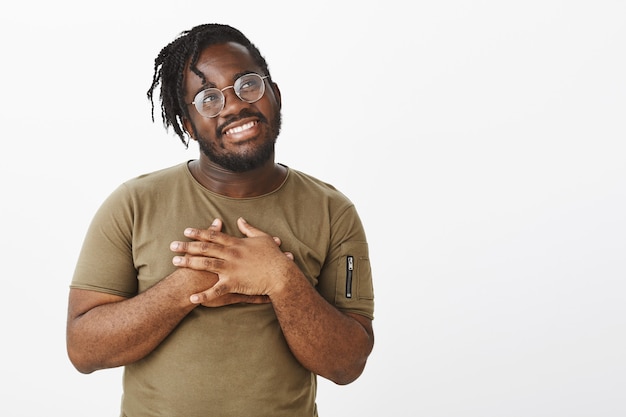 Photo gratuite plan intérieur d'un mec mignon avec des lunettes posant contre le mur blanc