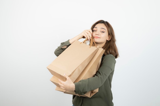 Plan d'une jeune mannequin féminine avec des sacs d'artisanat debout sur du blanc. Photo de haute qualité