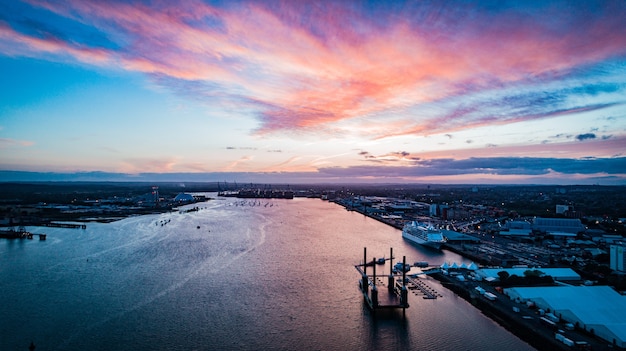 Plan large et lointain de bateaux flottant sur le plan d'eau de la ville sous un ciel rosé