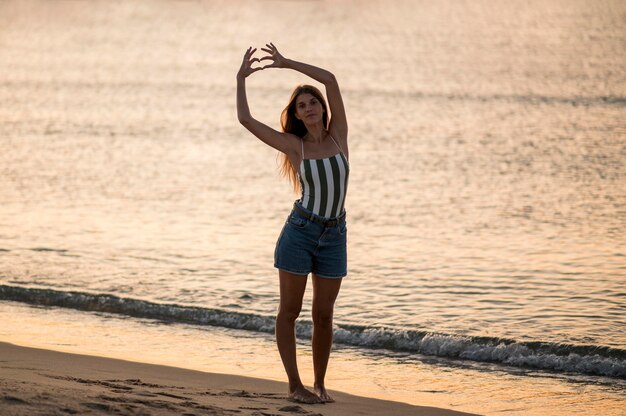 Plan long de la belle fille à la plage