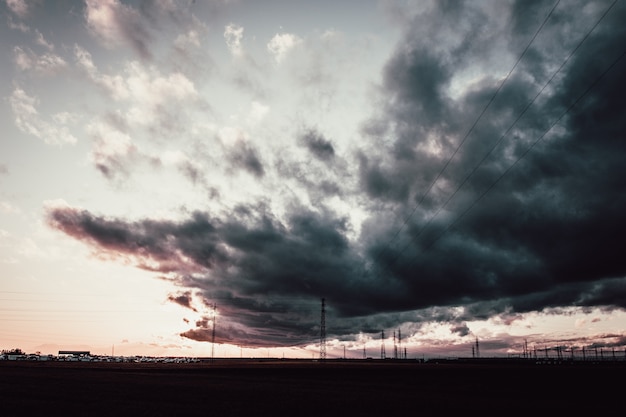 Plan long d'un ciel nuageux sombre au-dessus des tours d'antenne