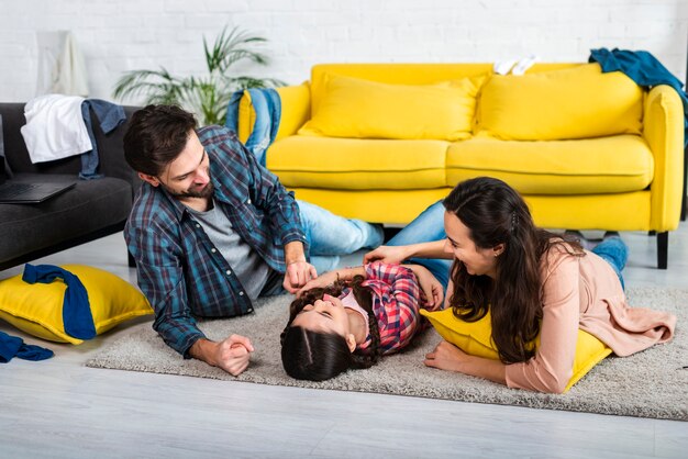 Plan long d'une famille heureuse et d'un salon en désordre