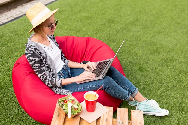 Plan long d'une femme travaillant sur son ordinateur portable