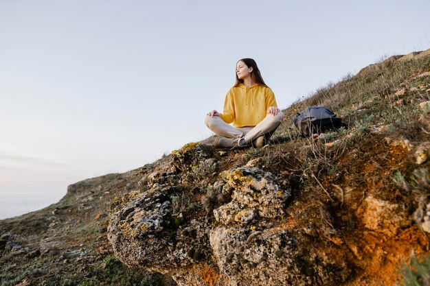 Plan long de la jeune femme appréciant la nature autour d'elle