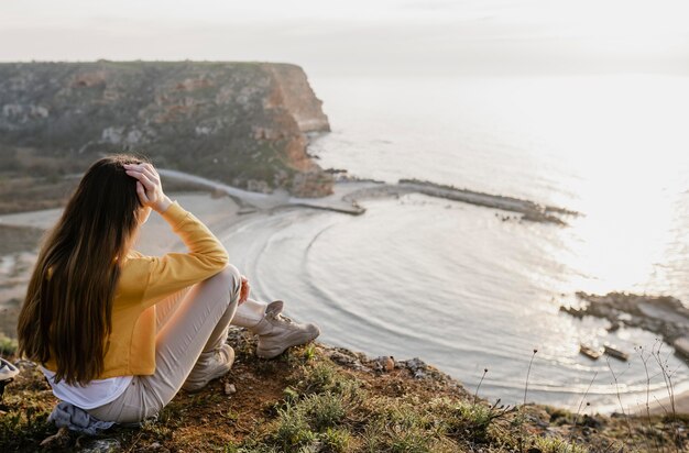 Plan long de la jeune femme appréciant la nature autour d'elle