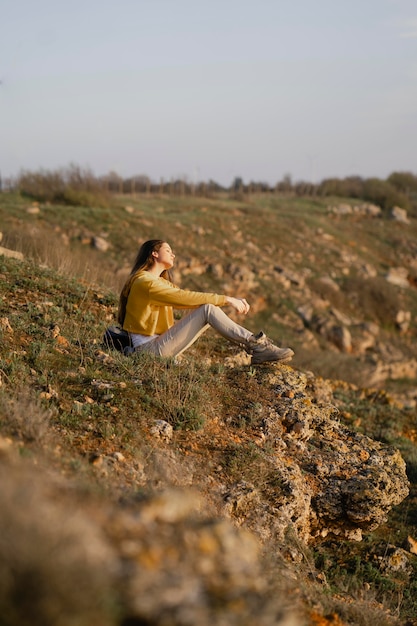 Plan long de la jeune femme appréciant la nature autour d'elle