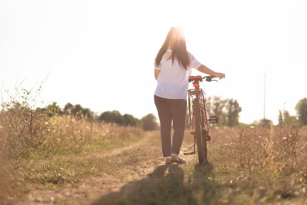 Plan long d'un jeune homme et d'un vélo