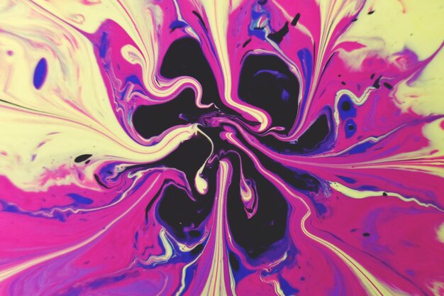 Plan macro d'un mélange abstrait d'éclaboussures de peinture acrylique colorée sur fond noir