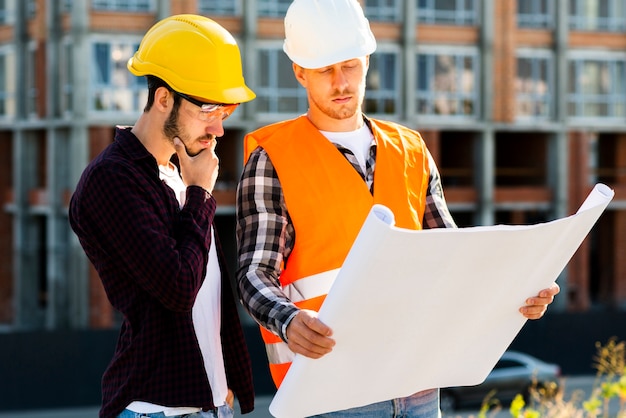 Plan moyen d&#39;architecte et d&#39;ingénieur examinant des plans