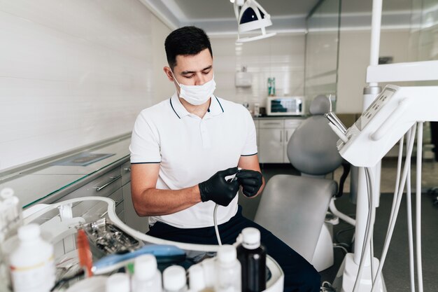 Plan moyen du dentiste vérifiant le matériel chirurgical