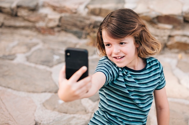 Plan moyen d'un enfant prenant un selfie