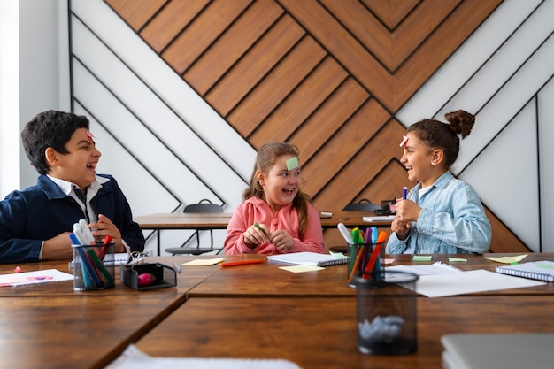 Photo gratuite plan moyen des enfants qui apprennent à l'école