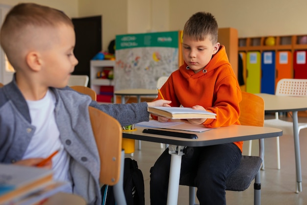 Photo gratuite plan moyen des enfants qui apprennent à l'école