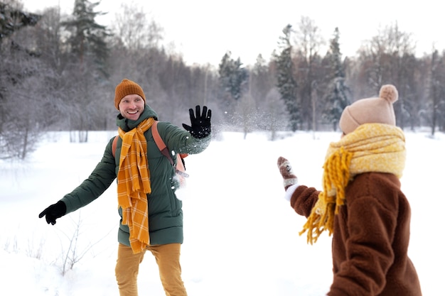 Plan moyen de la famille jouant avec la neige