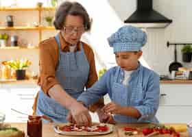 Photo gratuite plan moyen femme et enfant cuisinant ensemble