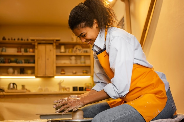 Plan moyen femme faisant de la poterie