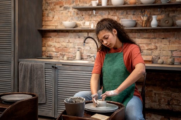 Plan moyen femme faisant de la poterie