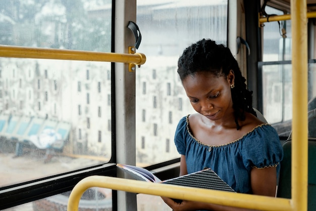 Plan moyen femme lisant dans le bus