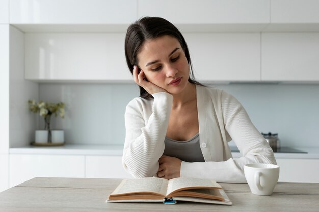 Plan moyen femme lisant à la maison