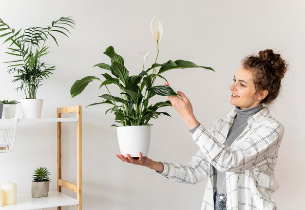 Plan moyen femme tenant une plante