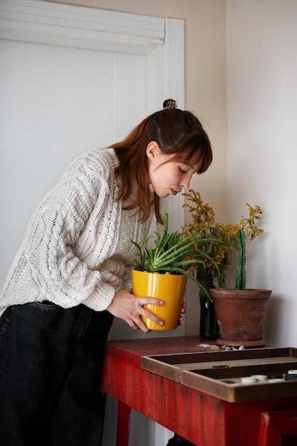 Plan moyen femme tenant une plante