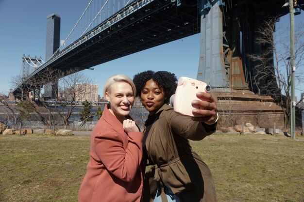 Plan moyen femmes prenant des selfies à l'extérieur