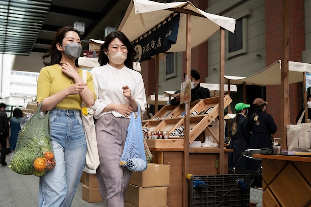 Plan moyen femmes transportant des provisions dans un sac fourre-tout